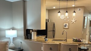 A modern kitchen with a central island, bar stools, and pendant lighting. -  Lake Life Luxury, Lake Geneva, Short Walk To Downtown, Pool View Upgraded Suite (Lake Geneva)
