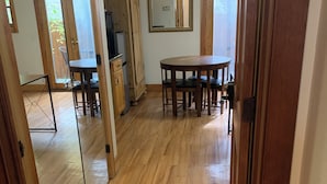 A room with a wooden floor, a dining table with chairs, a kitchen area with cabinets, and a mirror on the wall. - Cozy quite private Aspen Studio  (Aspen)