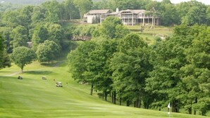 A golf course with a clubhouse in the background. - Cozy Pet-Friendly Studio! Land of Oz ! Festivals! (Beech Mountain)