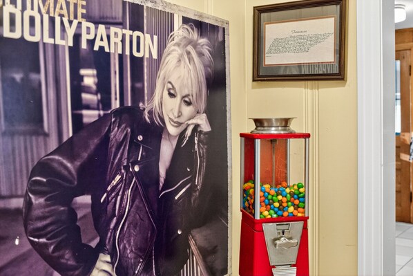 A vintage poster of Dolly Parton, a red candy vending machine, and a framed text on the wall. - Porch view of sunrise, moonrise & lightening bugs - Retreat 3mi to downtown! (Nashville)