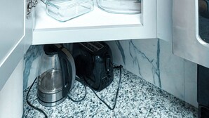 A kitchen with white cabinets, a marble countertop, and a coffee maker. - Cute and affordable 3BDR duplex in Overland Park for up to 12 people! (Overland Park)