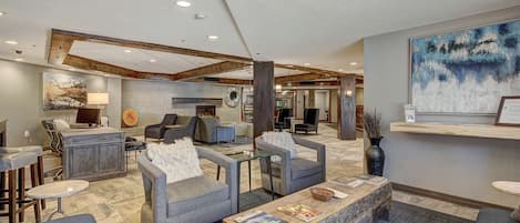A spacious lobby with a fireplace, comfortable seating, and a reception desk.