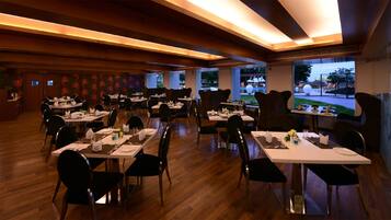 A restaurant with wooden flooring and tables set for dining.