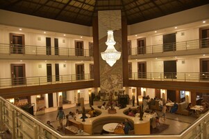 A multi-level atrium with a central chandelier, multiple seating areas, and a high ceiling.