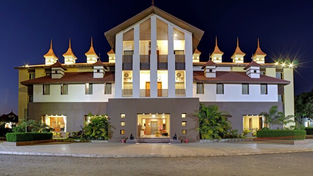 Ein modernes Hotel mit zentralem Eingang, mehreren Balkonen und traditionellen architektonischen Elementen.