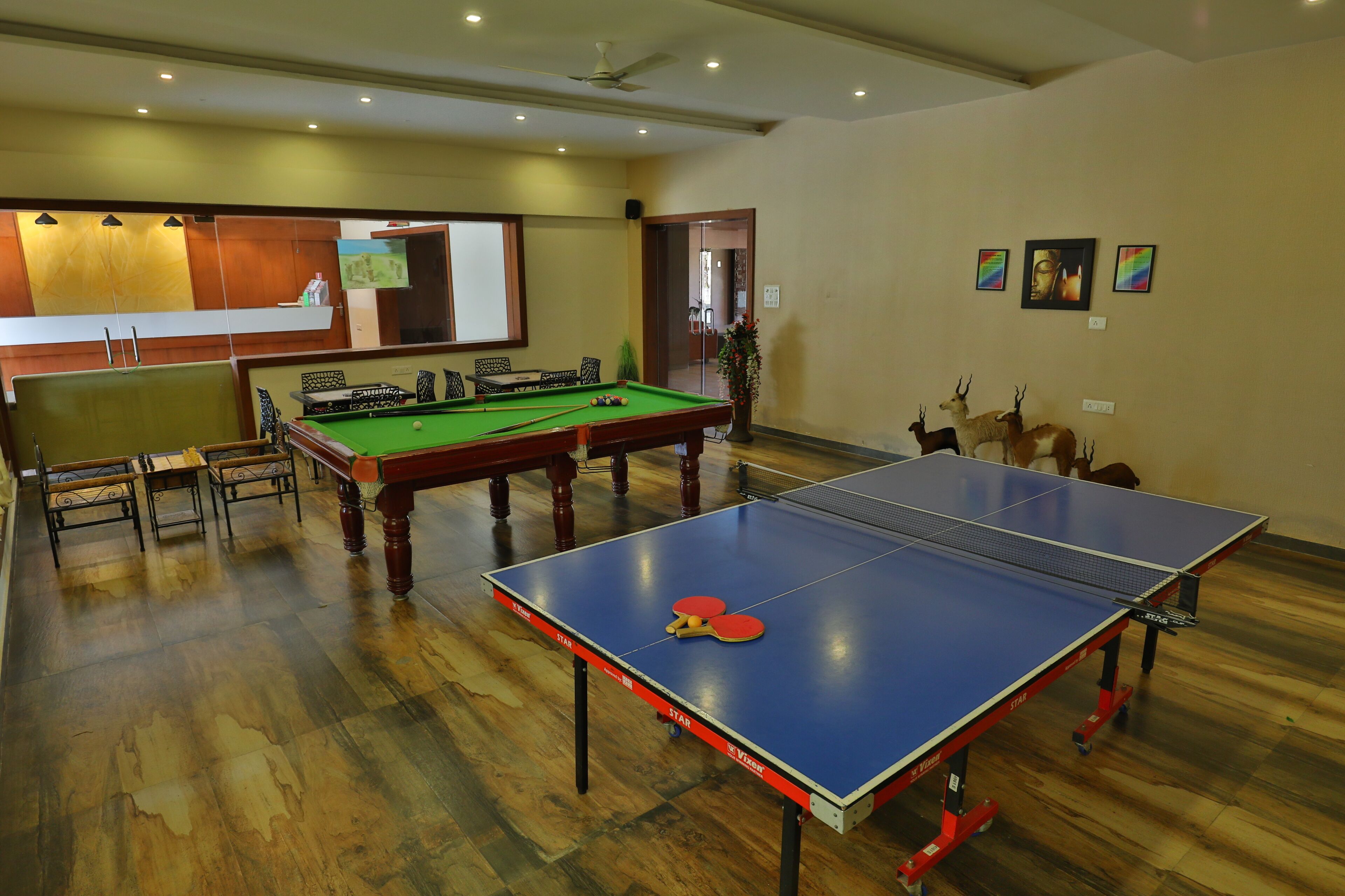 Una sala de billar con mesa de billar, mesa de snooker y mesa de futbolín.