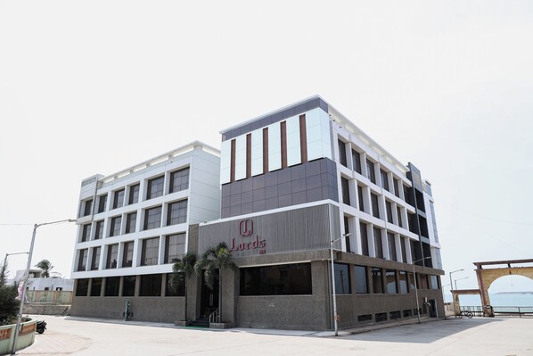 A modern building with a flat roof, large windows, and a prominent entrance. - Lords Inn Porbandar (Porbandar)