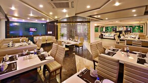 Un restaurant amb diverses sales de dinar, incloent seients a caixa i taules, i una decoració interior moderna.
