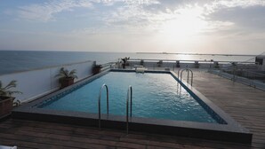 Una piscina a un pont amb vista al mar i un pont altre al lluny.
