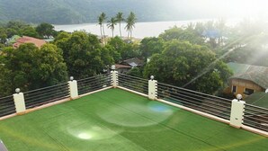 A boxing ring on a rooftop with a view of a lake and palm trees. - The Inn at Calayo (Nasugbu)