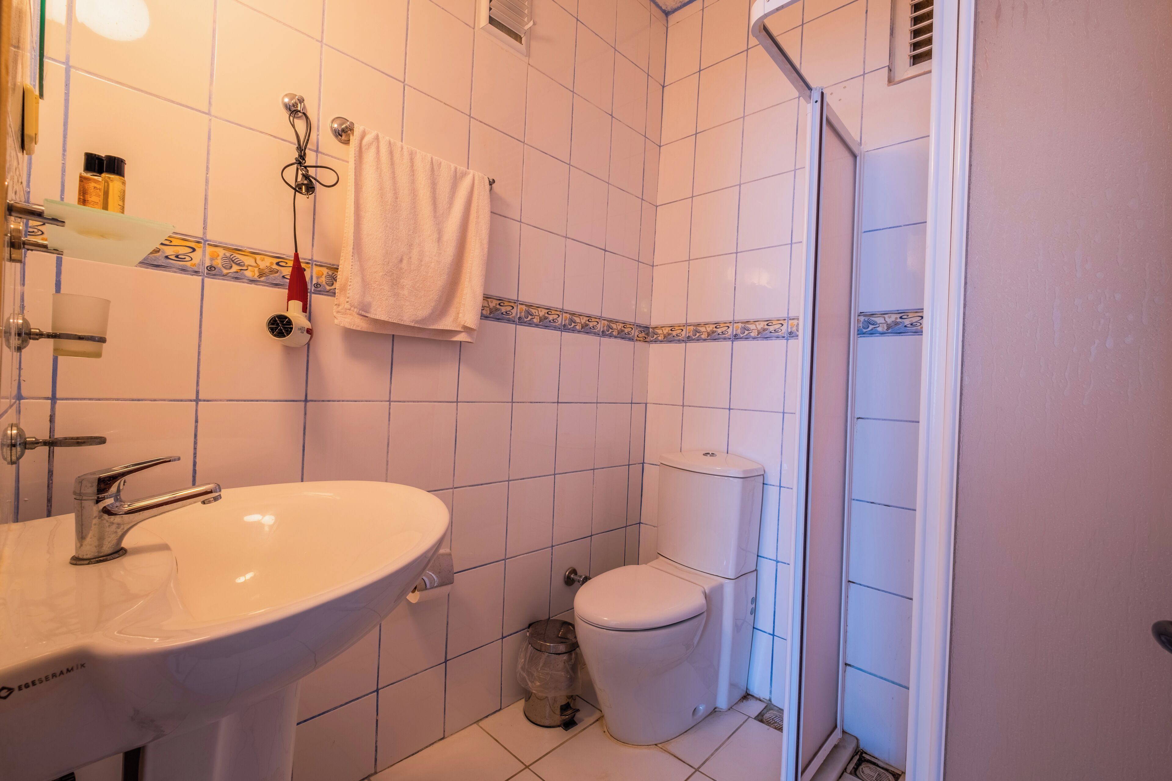 Un baño con lavamanos, inodoro y ducha.