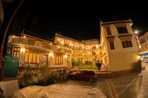 A two-story building with a balcony and a car parked in front.