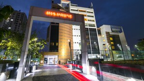 Een moderne hotelingang met een opvallend bord waarop 