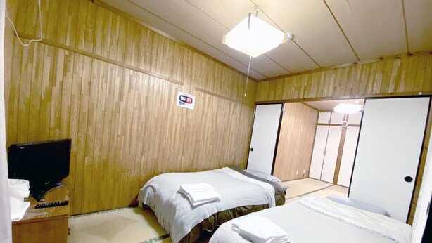 Ett hotellrum med två sängar, en TV och en skylt som visar att det finns kostnadsfritt Wi-Fi.