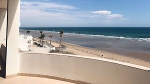 Un balcon avec vue sur une plage et l’océan.