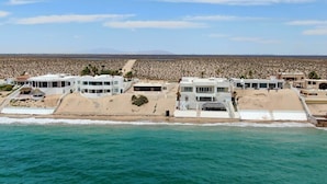 Un hôtel situé sur la côte, composé de plusieurs bâtiments, avec une plage de sable et une vue sur l’océan.