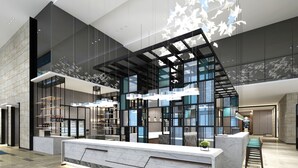 Una moderna zona de recepción con mostrador de mármol, divisiones de vidrio e iluminación colgante.