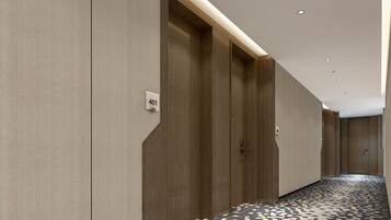 A hallway with a patterned floor, wooden doors, and a number sign indicating room 401.
