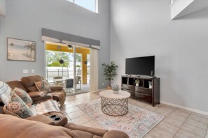 Relax in this inviting living room with a comfortable sofa, flat-screen TV, and potted plant.