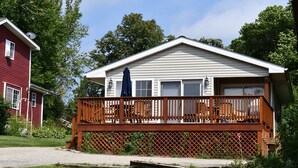 A two-story house with a wooden deck and a garage.