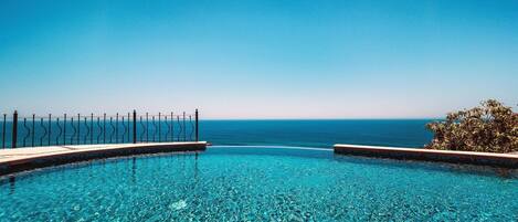 Una piscina azul cristalina con vista al océano.