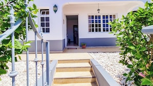 A white building with a tiled entrance and a staircase leading up to a door. - Casa da Achada in Arco da Calheta (Arco da Calheta)