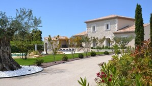 A villa with a stone facade, a tiled roof, and a well-maintained garden with a pool and outdoor seating. - Provencal country house with heated freeform pool (Châteaurenard)