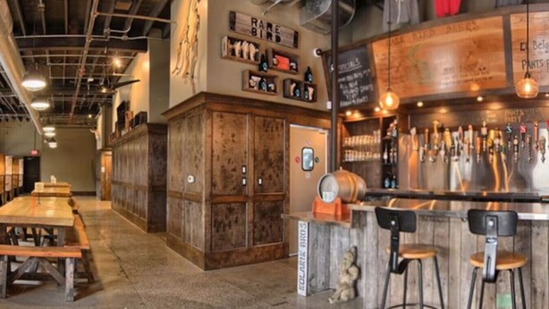 A bar area with wooden furniture, a bar counter, and a variety of beer taps. - Top-Floor 1-Bedroom Condo in Downtown Traverse City – Walk to Beaches & Dining (Traverse City)