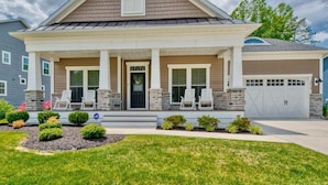 A two-story house with a front porch, a garage, and a well-maintained lawn.