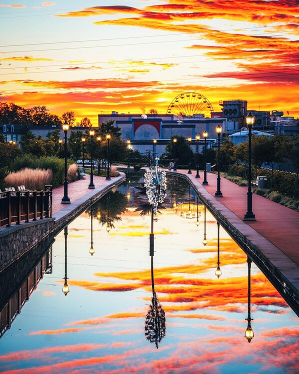 A sunset over a canal with a Ferris wheel in the background. - RETREAT on the CREEK - Businees Travelor or Weekend Getaway. HISTORIC DISTRICT. (Frederick)