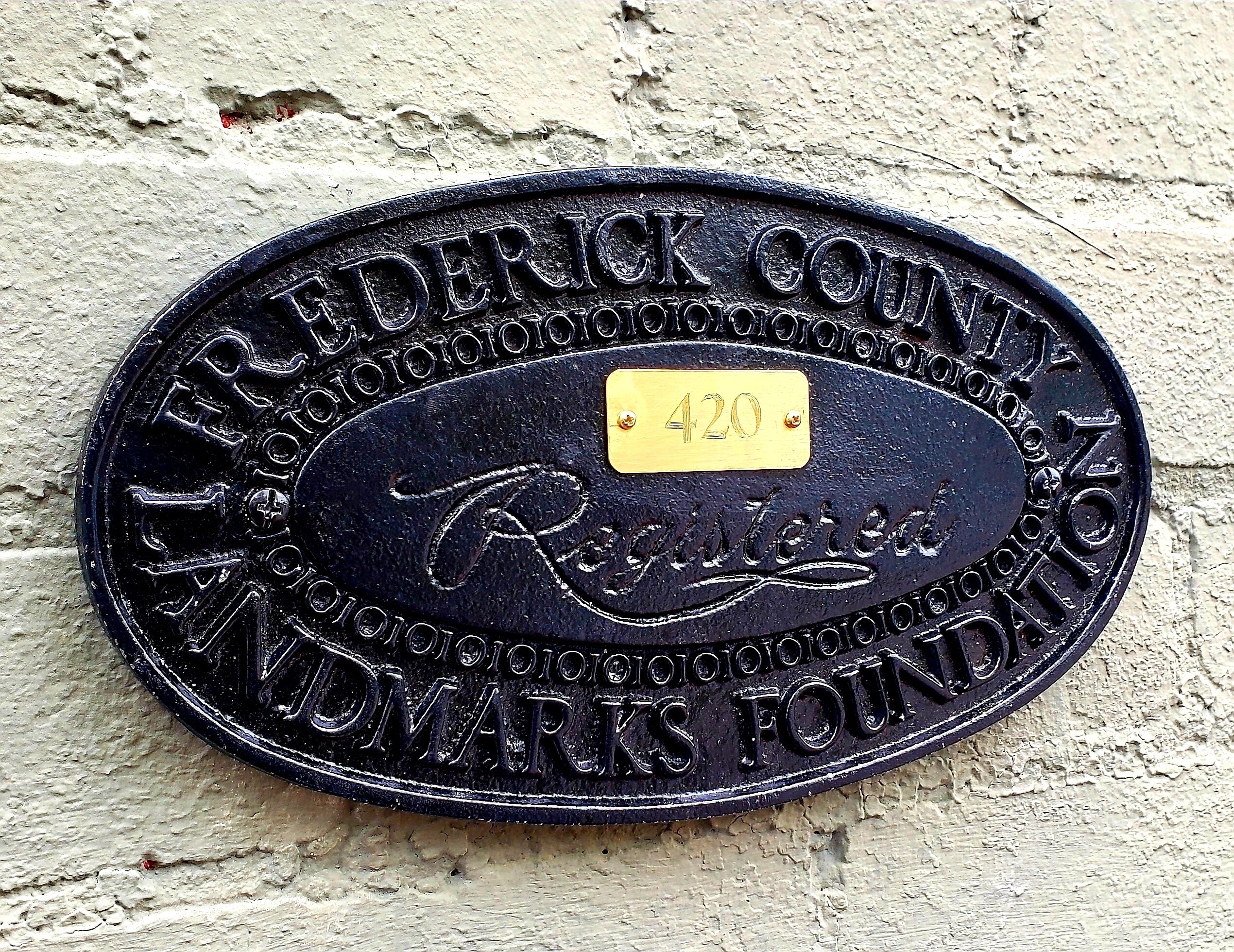 Een metalen plaquette met de tekst 'Frederick County, Randolph, Indiana, Foundation' en een geel label met het nummer '420'.