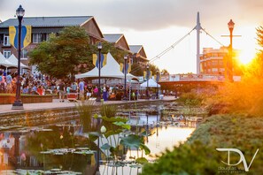A riverside walkway with a bridge, tents, and a crowd of people. - RETREAT on the CREEK - Businees Travelor or Weekend Getaway. HISTORIC DISTRICT. (Frederick)