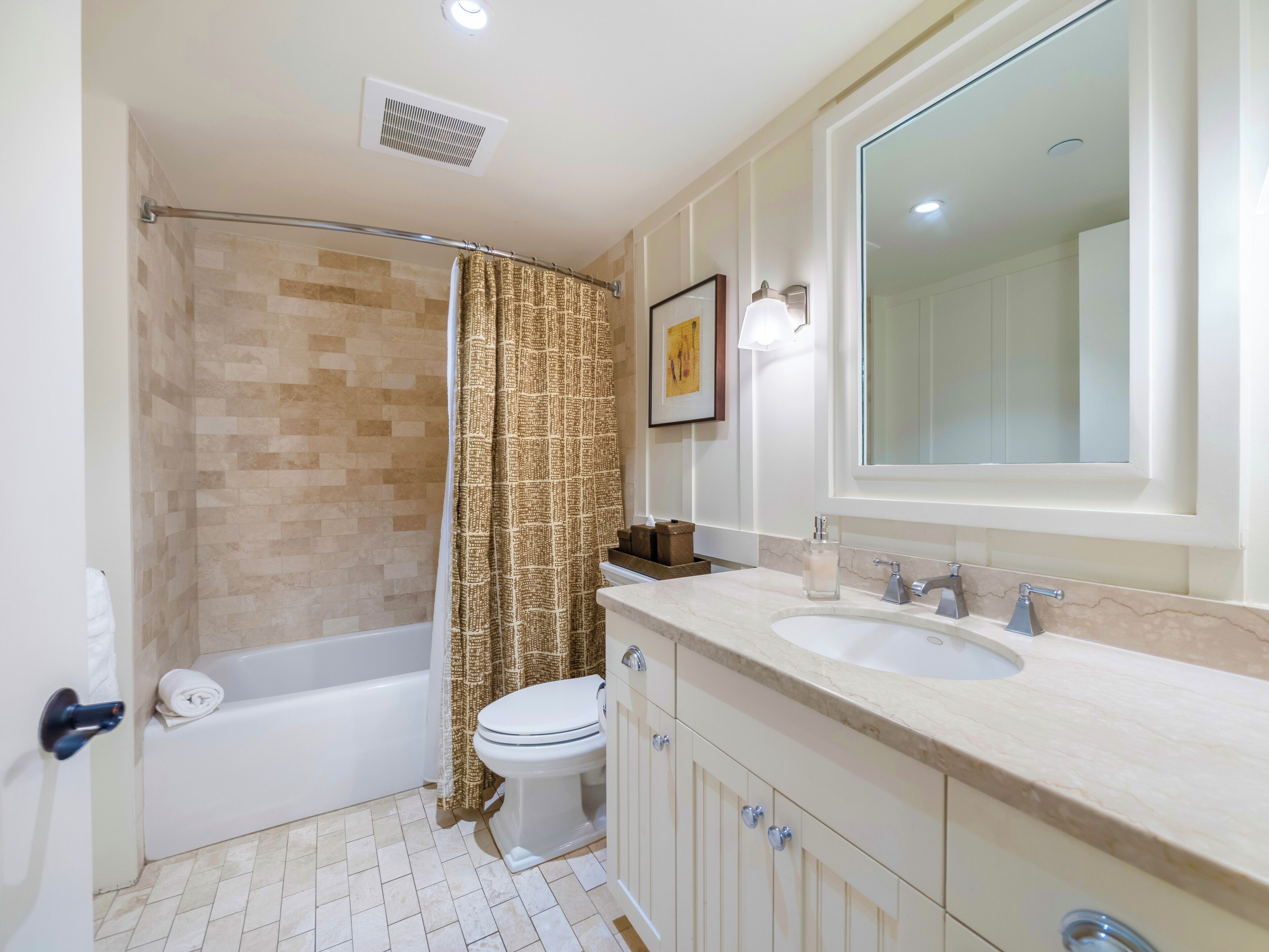 A bathroom with a bathtub, toilet, and sink.