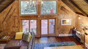 A spacious loft with a high ceiling, large windows, and a cozy seating area.