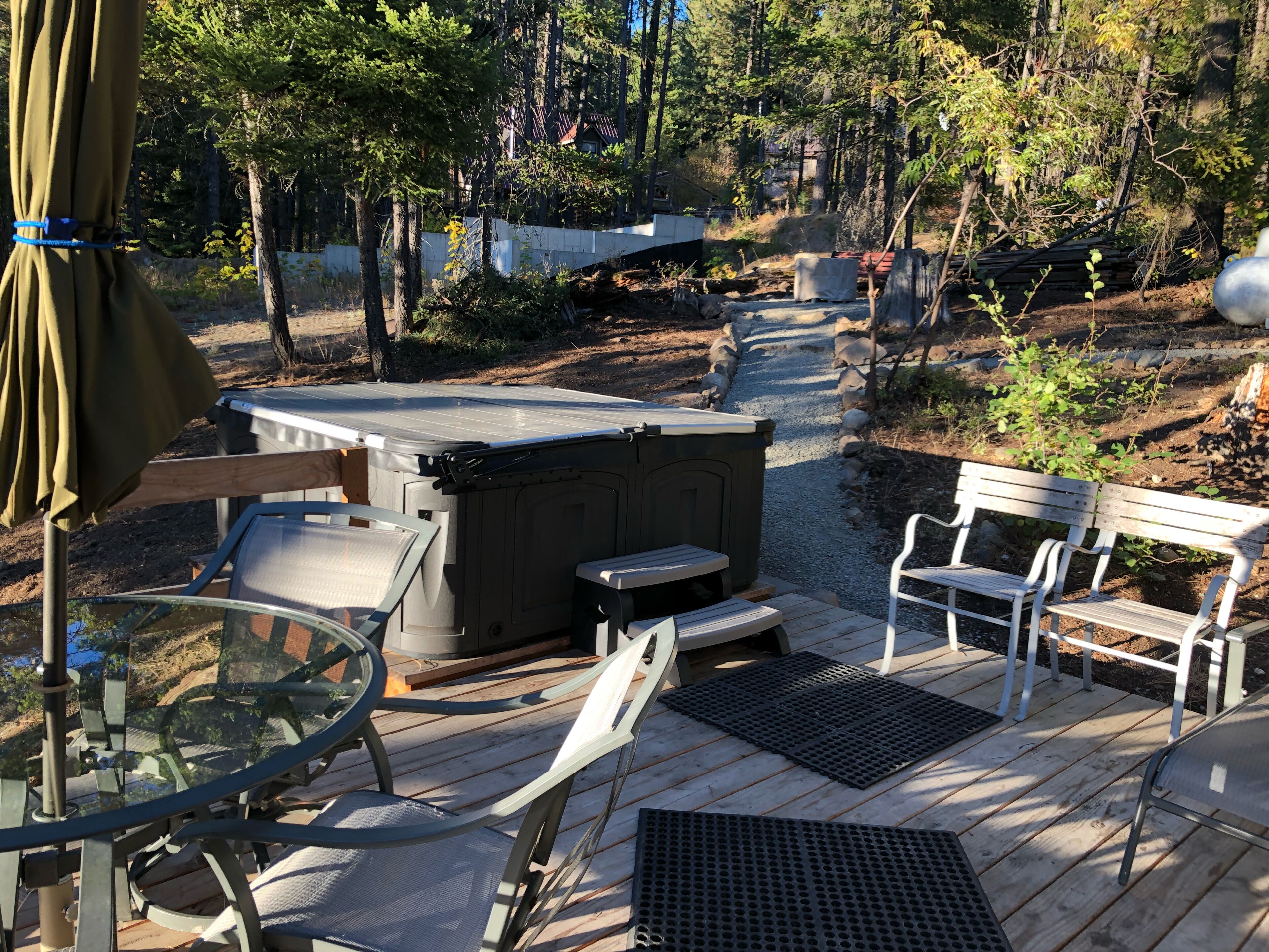 Una terraza con mobiliario exterior, un jacuzzi y un camino de piedra.
