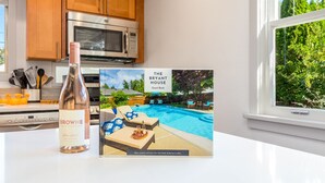 A kitchen with a bottle of wine, a guest book, and a poolside view. - HEATED Pool & Hot Tub in a Quiet Neighborhood- Walk to Town- Dog Friendly (Walla Walla)