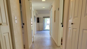 A hallway with white doors, a light wooden floor, and a ceiling with recessed lighting. -  Desert Oasis, Golf, Stunning Southwest Mountain Views, Serene and Private! (Palm Desert)