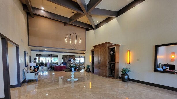 A spacious lobby with a polished marble floor, a wooden reception desk, and a large chandelier. -  Desert Oasis, Golf, Stunning Southwest Mountain Views, Serene and Private! (Palm Desert)