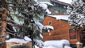 Un edificio di legno con un cartello che riporta la scritta "Copper Junction" in un paesaggio innevato.