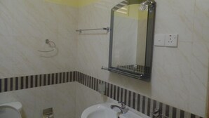 A bathroom with a white sink, a mirror, and a towel rack. - Peace Heaven (Udawalawa)