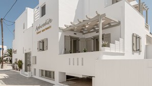 Un edifici modern i blanc amb un rètol que diu "Aphrodite Luxury Apartments".