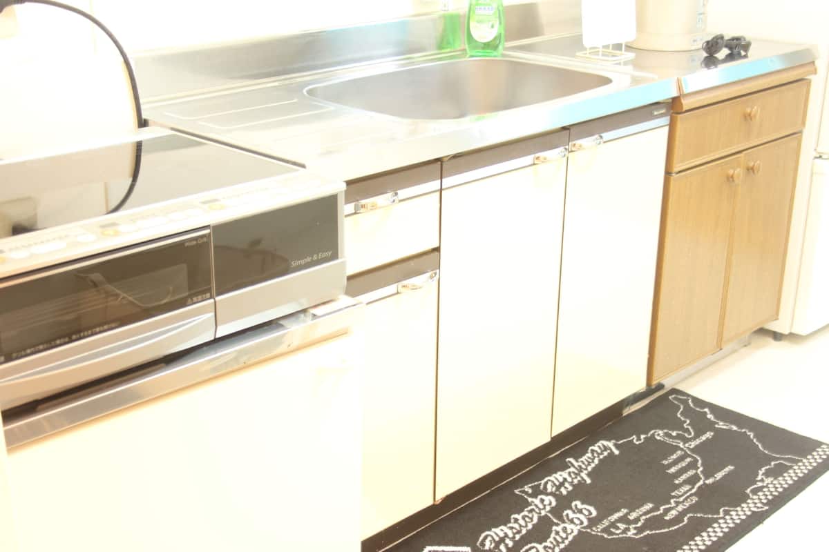 A kitchen with a dishwasher, oven, and a stainless steel sink.