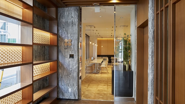 Ein modernes Interieur mit Holzregalen, einer Steinwand und Blick auf den Essbereich.