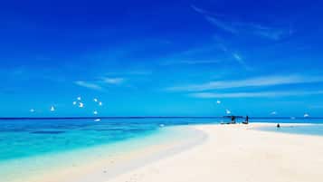 Di pantai, pasir putih, kerusi lepak pantai, payung