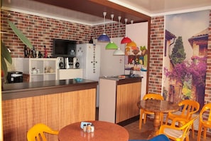 Enjoy cooking and dining in this well-equipped kitchen with a refrigerator, microwave, and flat-screen TV.