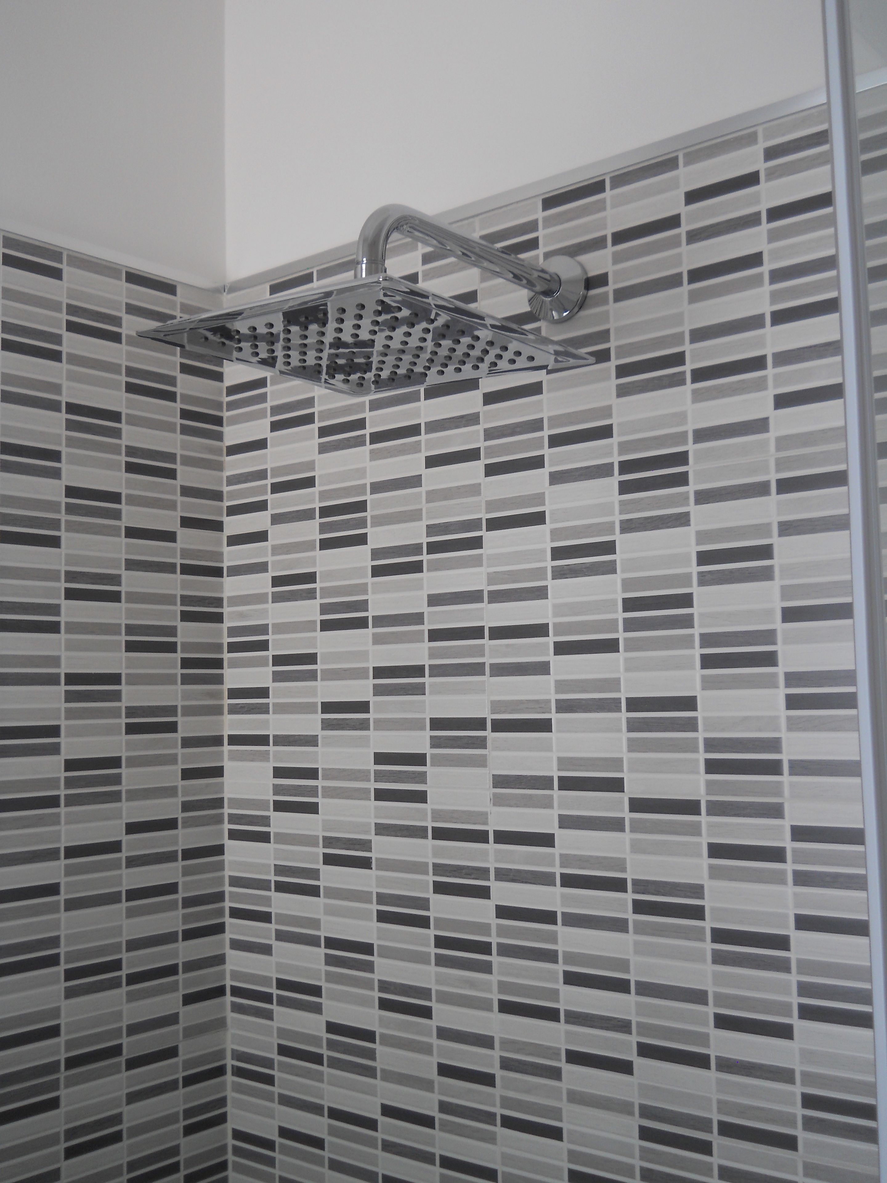 Una doccia con un moderno soffitto forato.