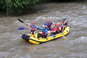 A group of people in a yellow raft navigating a river.