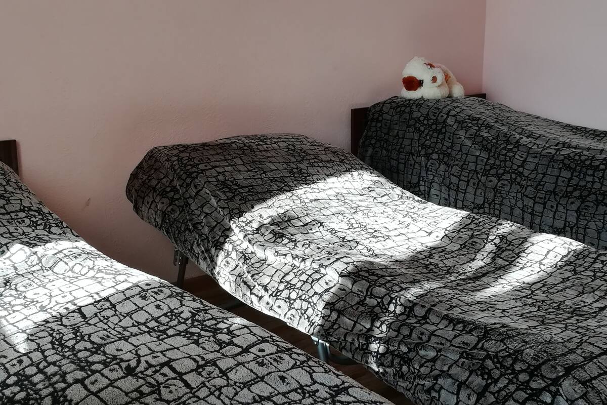 Una habitación con dos camas, cada una con ropa de cama estampada.