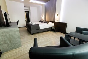 A modern hotel room with a bed, bedside table, and a desk with chairs. - Hotel U Kostela (Modrice)