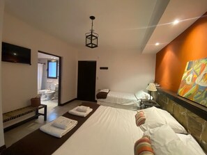 A hotel room with two beds, a sitting area, a bathroom, and a painting on the wall. - Hotel Las Chirimoyas  (Salta)